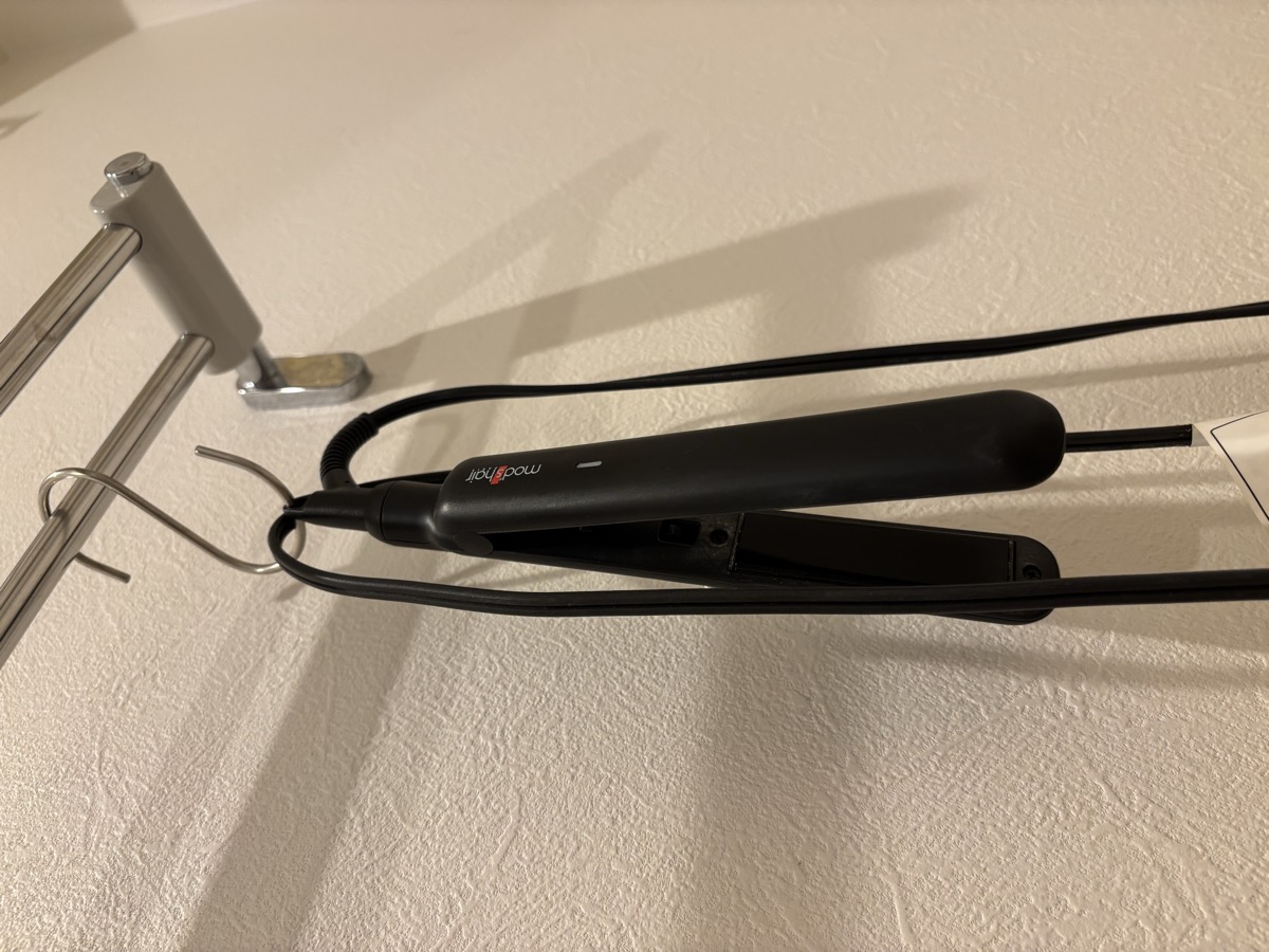 mod's hairのミニアイロンを洗面所のバーにS字フックで吊るしている様子